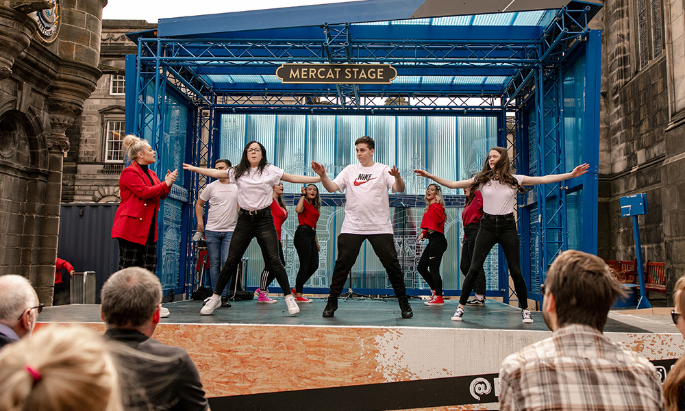 A class of schoolkids performs on the outdoor Mercat stage as part of the Fringe street events. Photo credit: Schools on the street (2019). Photographer: David Wilkinson.
