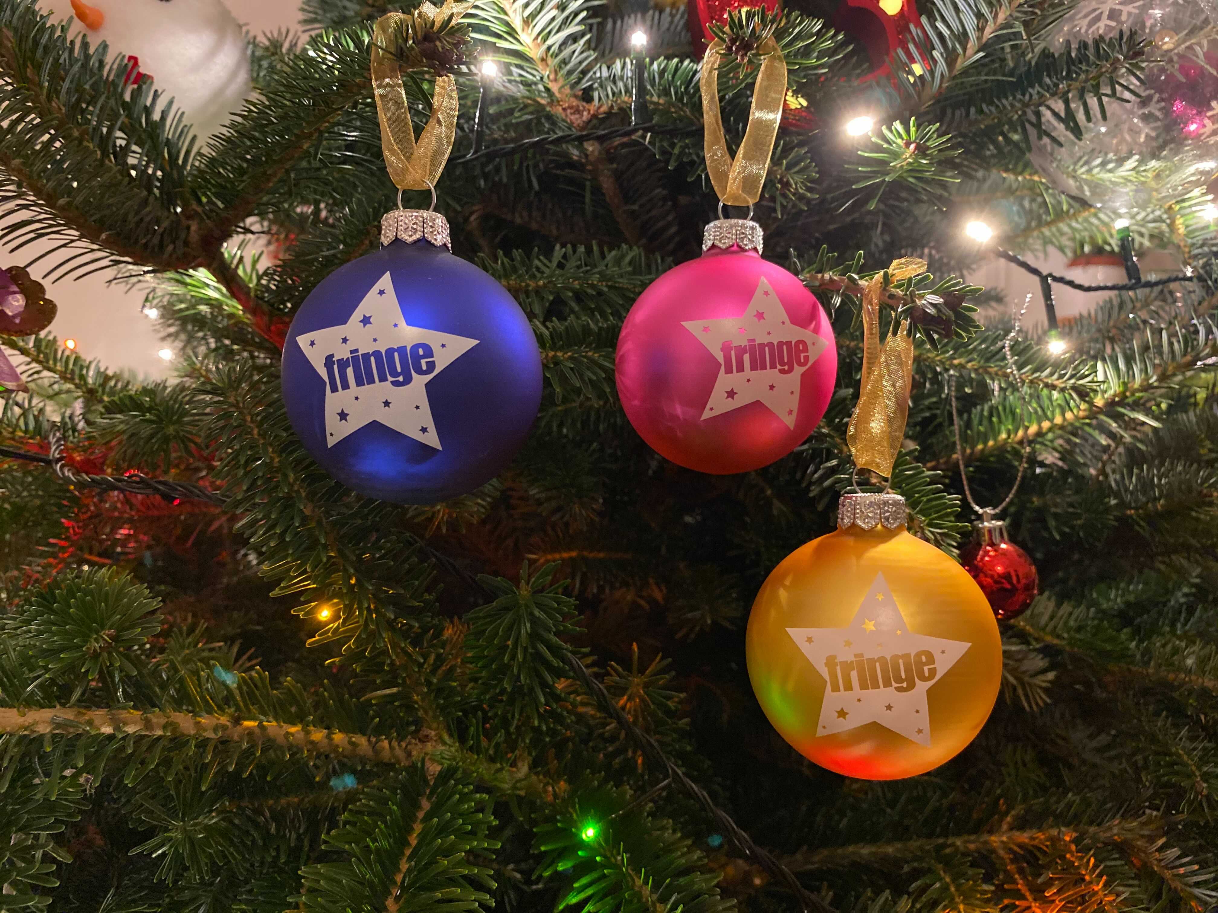 Fringemas baubles hanging on a Christmas tree.